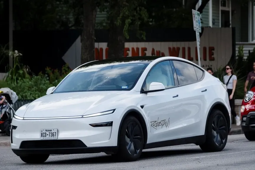 A Tesla robotaxi drives on the street along South Congress Avenue in Austin, Texas